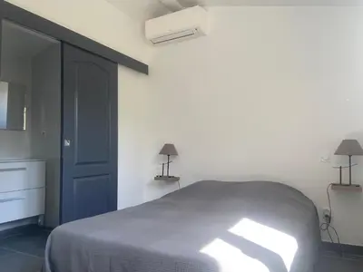 a bedroom with a bed and a blue door at Residence Les Jardins de Sainte-Lucie 
