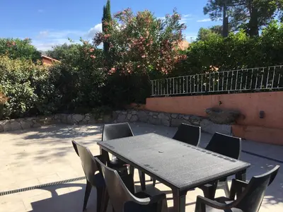 a wooden table and chairs with a table and a table and chairs at Residence Les Jardins de Sainte-Lucie 