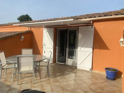 a patio with a table and chairs and a patio umbrella at Residence Les Jardins de Sainte-Lucie 