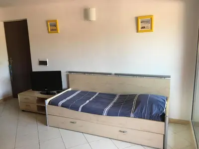 a bedroom with a bed and a desk with a television at Residence Les Jardins de Sainte-Lucie 