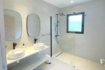 a white bathroom with two sinks and a shower at Villa Concarella Di Conca in Conca
