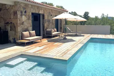 a swimming pool with a wooden deck and an umbrella at Villa Concarella Di Conca in Conca