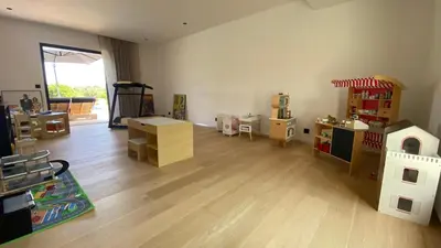 a room with wooden floors and a play room with a toy house at Villa A Licciola in Porto-Vecchio