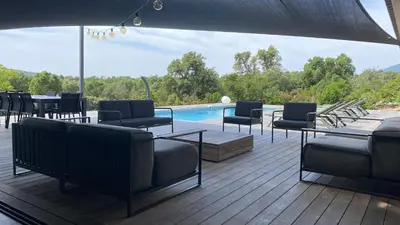 a patio with chairs and tables and a swimming pool at Villa A Licciola in Porto-Vecchio