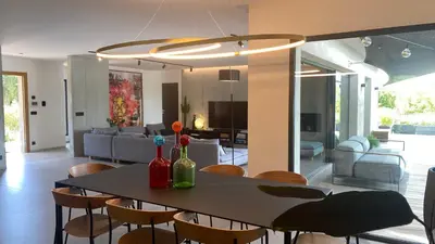 a dining room and living room with a table and chairs at Villa A Licciola in Porto-Vecchio