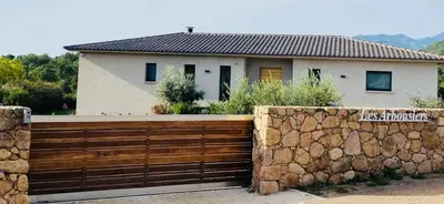 a house with a fence and a stone wall at Villa A Licciola in Porto-Vecchio
