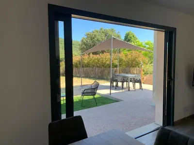 a view of a patio with a table and an umbrella at A casetta maison de plain pied in Sartène