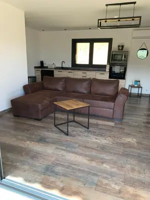 a living room with a brown couch and a table at A casetta maison de plain pied in Sartène