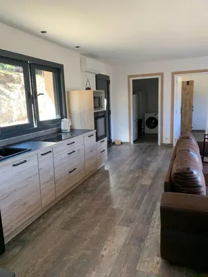 a living room with a couch and a kitchen at A casetta maison de plain pied in Sartène