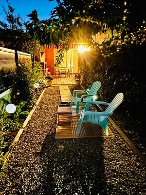 a backyard with a wooden deck with green chairs at Casa Marana in Borgo