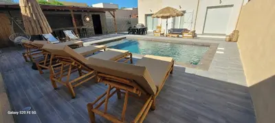 a swimming pool with lounge chairs and a swimming pool at Villa individuelle 3 chambres - 6 pers in Calvi