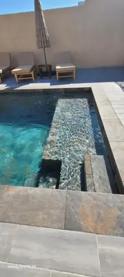 a swimming pool with two chairs and a umbrella at Villa individuelle 3 chambres - 6 pers in Calvi