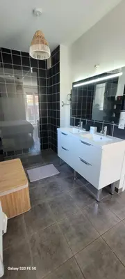 a bathroom with two sinks and a large mirror at Villa individuelle 3 chambres - 6 pers in Calvi