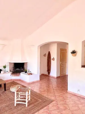 a living room with a table and a fireplace at Maison Pinarellu plage à pieds in Zonza