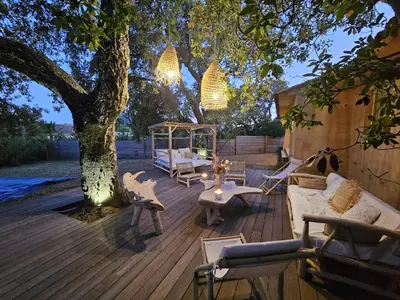a patio with a tree and a couch and a table at Maison Pinarellu plage à pieds in Zonza