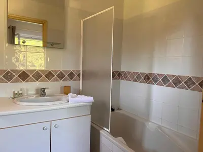 a bathroom with a sink and a bath tub at Maison Pinarellu plage à pieds in Zonza