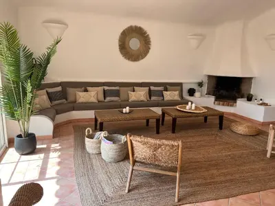 a living room with a couch and tables and a fireplace at Maison Pinarellu plage à pieds in Zonza