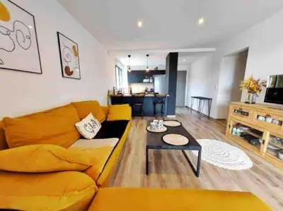 a living room with a yellow couch and a table at Charmant T3 à Porticcio in Porticcio