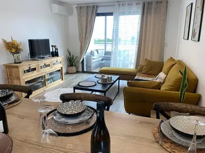 a living room with a couch and a table at Charmant T3 à Porticcio in Porticcio