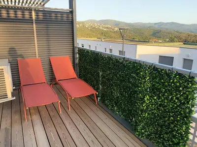 two red chairs sitting on top of a balcony at Charmant T3 à Porticcio in Porticcio