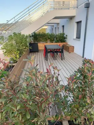 a wooden deck with a table and chairs on a house at Charmant T3 à Porticcio in Porticcio