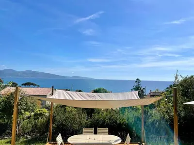 a hammock with a view of the ocean at Maison en bord de mer in Coggia