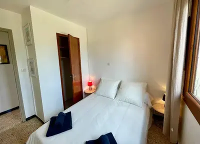 a bedroom with a white bed and a red lamp at Maison en bord de mer in Coggia
