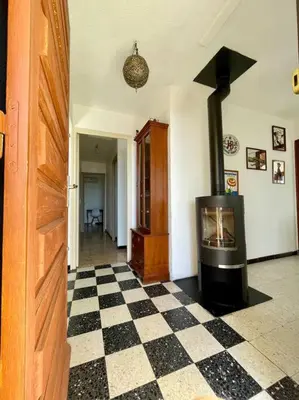 a fireplace in a living room with a checkered floor at Maison en bord de mer in Coggia