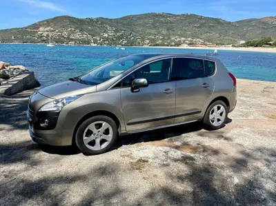 a silver car parked next to a body of water at Maison en bord de mer in Coggia