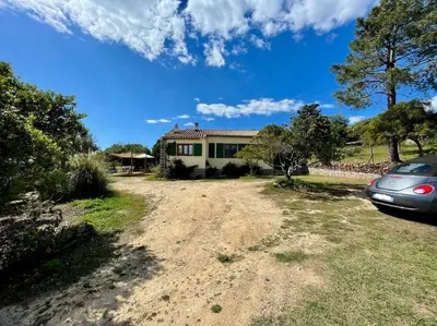 a house with a car parked in front of it at Maison en bord de mer in Coggia