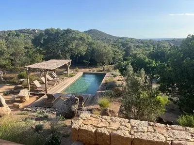 a swimming pool in the middle of a field with trees at Villa Valle di Corte - Avec piscine et vue mer in Pianottoli-Caldarello