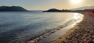 a beach with the sun rising over the water at Studio grande piscine dans résidence hôtelière, proche plage in Lecci