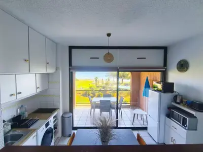a kitchen with a table and a dining room at Grand studio les pieds dans l'eau in San-Nicolao