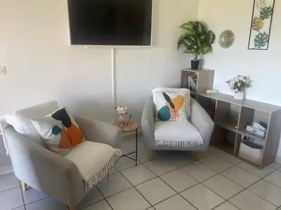 a living room with two chairs and a flat screen tv at Grand studio les pieds dans l'eau in San-Nicolao