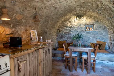 a kitchen with a table and chairs in a room at Magnifique Bergerie RONDOLINO vue mer et montagne - U Sognu di Paomia in Cargèse