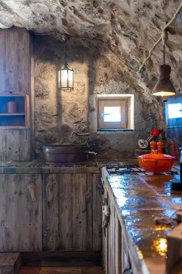 a kitchen with a counter and a stove top oven at Magnifique Bergerie RONDOLINO vue mer et montagne - U Sognu di Paomia in Cargèse