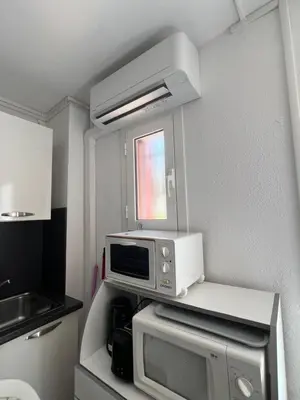 a small kitchen with a microwave on a counter at Résidence LO MONACO Haut de villa, Appartements et Studios in San-Nicolao
