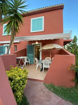 a house with a patio and a palm tree at Résidence LO MONACO Haut de villa, Appartements et Studios in San-Nicolao