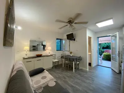 a living room and kitchen with a couch and a table at Résidence LO MONACO Haut de villa, Appartements et Studios in San-Nicolao