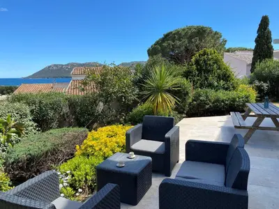 a patio with two chairs and a table and a table and chairs at Appartement Marina di Fiori by Intendance Excellency in Porto-Vecchio