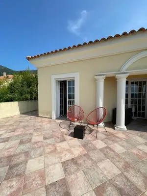 two chairs on a patio in front of a house at CASA DI CAJUCAN in Poggio-dʼOletta