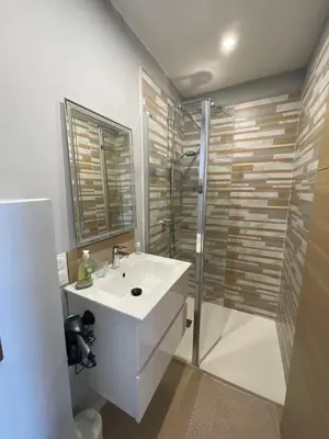 a white bathroom with a sink and a shower at CASA DI CAJUCAN in Poggio-dʼOletta