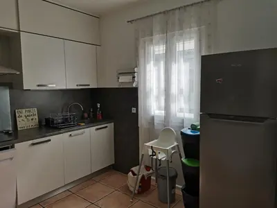 a kitchen with white cabinets and a black refrigerator at Rez Haut de villa à Calenzana in Calenzana