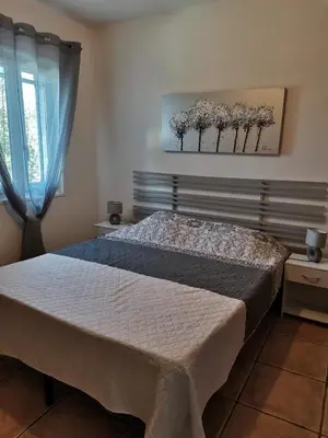 a bedroom with a bed and a painting on the wall at Rez Haut de villa à Calenzana in Calenzana