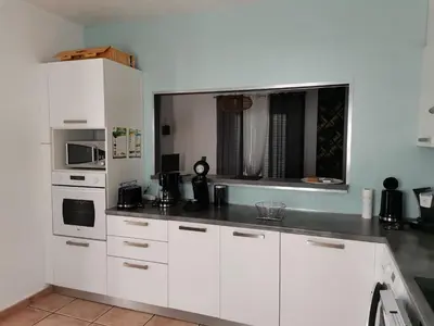 a kitchen with white cabinets and a counter top at Rez Haut de villa à Calenzana in Calenzana
