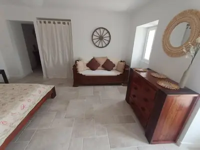 a living room with a couch and a mirror at Maison de charme proche Bastia in Prunelli-di-Casacconi