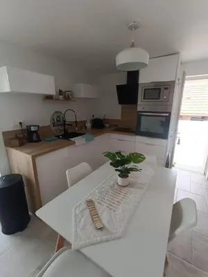 a kitchen with a white table with a plant on it at Maison de charme proche Bastia in Prunelli-di-Casacconi