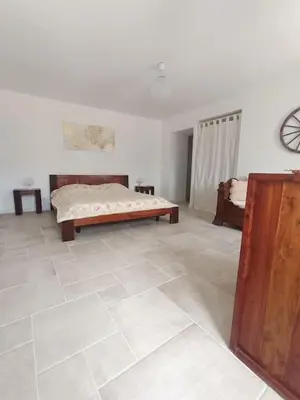 a bedroom with a bed and a tiled floor at Maison de charme proche Bastia in Prunelli-di-Casacconi