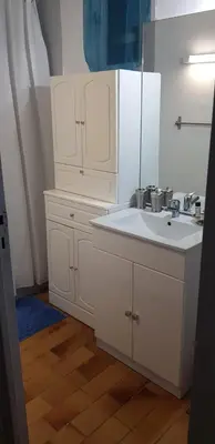 a white bathroom with a sink and a mirror at Charmant T3 en rez de jardin d'une villa in Ghisonaccia
