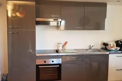 a kitchen with a stainless steel refrigerator and a sink at Charmant T3 en rez de jardin d'une villa in Ghisonaccia